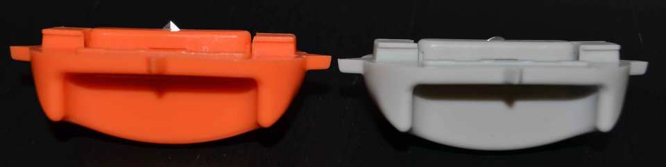 Das orange Schiffchen links hält eine spitze Schneideklinge; im grauen Schiffchen rechts ist die abgerundete Falzklinge versenkt.