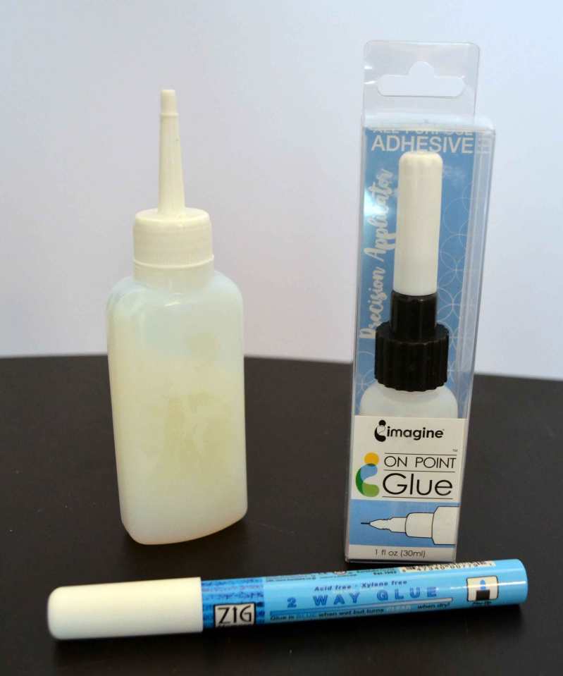 Meine liebsten Flüssigkleber. Links ein Allzweckbastelkleber von Folia, rechts der On Point Glue für sehr feine Klebearbeiten, vorne der ZIG 2 Way Glue.